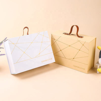 Custom Gold Geometric Line Magnetic Book-Style Gift Box with Leather Handle | Cream White Gold Forest Green Gold Foil Grid & Good Luck Stamp Brown PU Leather Handle for Beauty Tea Health Holiday Gift Set | MOQ 100 pcs
